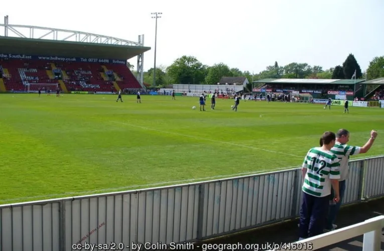 Bầu không khí sôi động bên trong sân vận động Kingfield vào ngày diễn ra trận đấu của Woking FC, thu hút hàng ngàn cổ động viên.