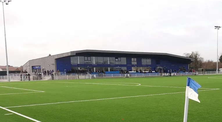 Cận cảnh khán đài chính và khu vực sân cỏ tại Parkside Stadium, trung tâm của Aveley FC
