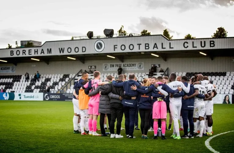 Đội hình Borehamwood FC chụp ảnh trước khán đài chính tại sân Meadow Park.