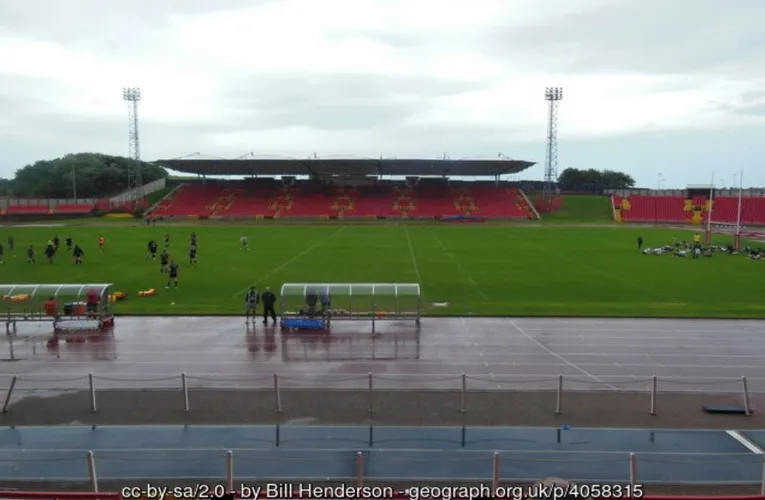 Góc nhìn từ khán đài chính tại Gateshead International Stadium, cho thấy đường chạy điền kinh và sân bóng đá