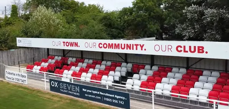 Khu vực khán đài có mái che tại St James Park Brackley, mang lại sự thoải mái cho người hâm mộ trong các trận đấu bóng đá Anh