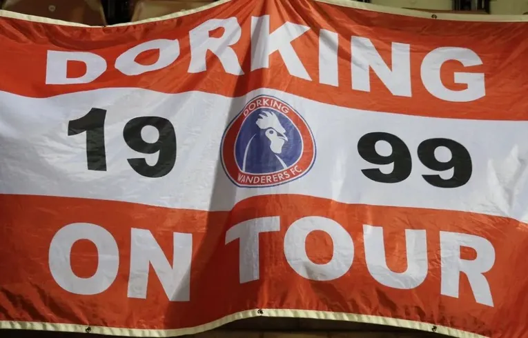 Lá cờ Dorking Wanderers FC với biểu tượng gà trống đặc trưng, thể hiện niềm tự hào và bản sắc câu lạc bộ tại sân Meadowbank.